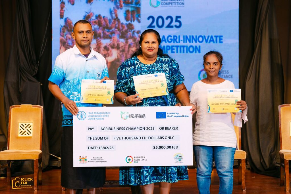 Three people hold up certificates and a cheque