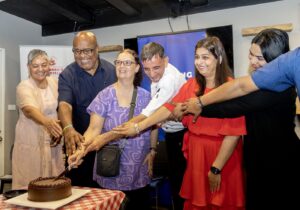 A group of people cut a cake together